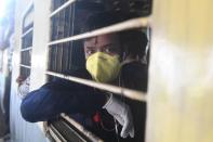 A passenger wearing a facemask travels in a train during a one-day Janata (civil) curfew imposed as a preventive measure against the COVID-19 coronavirus, at a railway station in Kolkata on March 22, 2020. - Nearly one billion people around the world were confined to their homes, as the coronavirus death toll crossed 13,000 and factories were shut in worst-hit Italy after another single-day fatalities record. (Photo by Dibyangshu SARKAR / AFP) (Photo by DIBYANGSHU SARKAR/AFP via Getty Images)