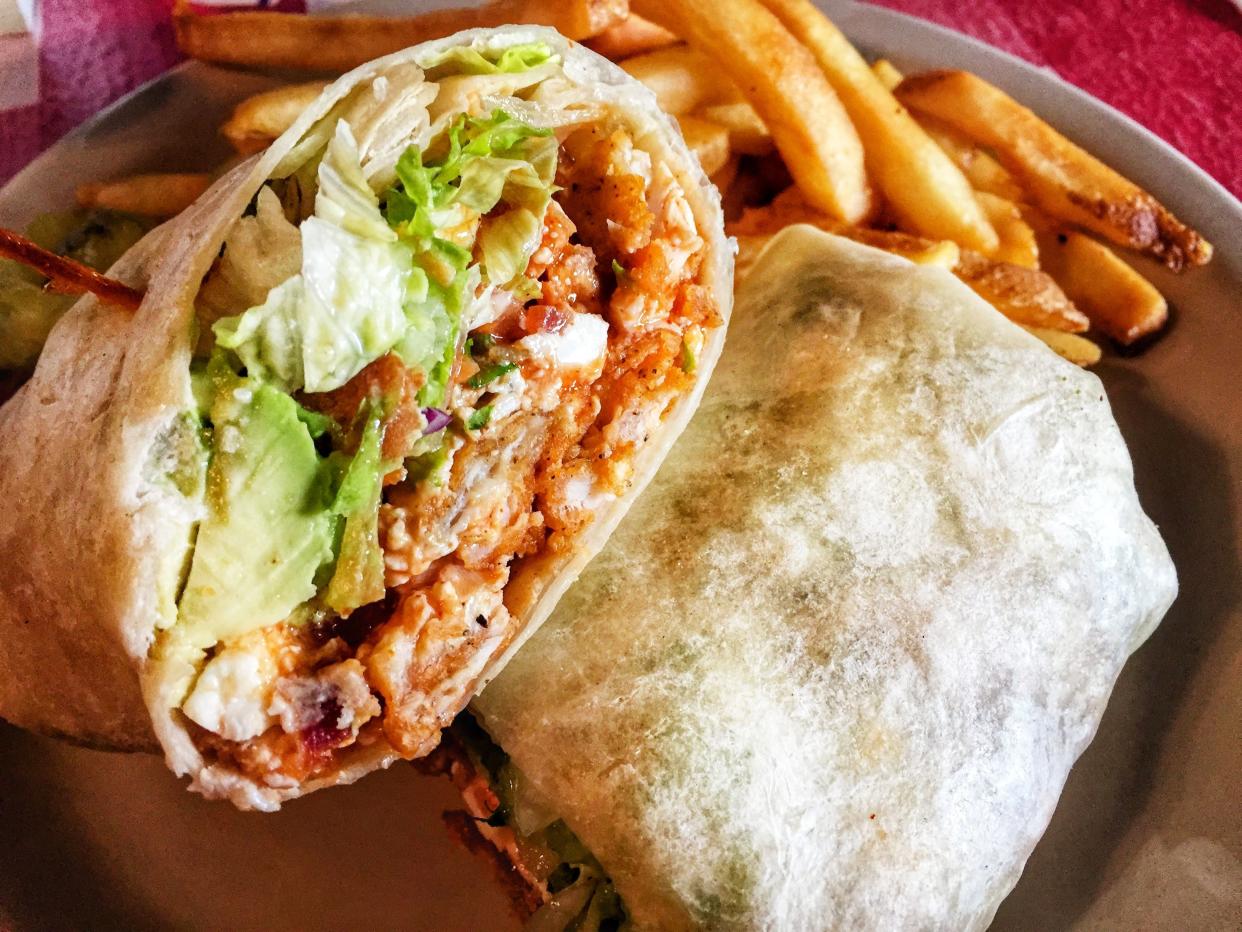 Spicy buffalo sauce coated crispy fried chicken breast, topped with blue cheese, avocado and lettuce. Fold it all up in an oversized tortilla and cut in half. Some fusion cuisine for you.