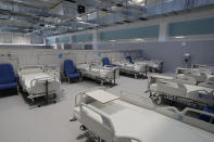 New beds sit in the empty Isabel Zendal new hospital during the official opening in Madrid, Spain, Tuesday, Dec. 1, 2020. Authorities in Madrid are holding a ceremony to open part of a 1,000-bed hospital for emergencies that critics say is no more than a vanity project, a building with beds not ready to receive patients and unnecessary now that contagion and hospitalizations are waning. Spain has officially logged 1.6 million infections and over 45,000 deaths confirmed for COVID-19 since the beginning of the year. (AP Photo/Paul White)