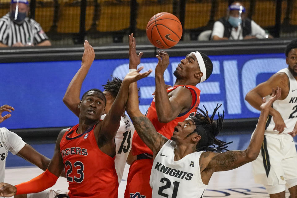 Auburn forward Jaylin Williams (23) and guard Devan Cambridge, center, battle Central Florida forward C.J. Walker (21) for a rebound during the second half of an NCAA college basketball game, Monday, Nov. 30, 2020, in Orlando, Fla. (AP Photo/John Raoux)