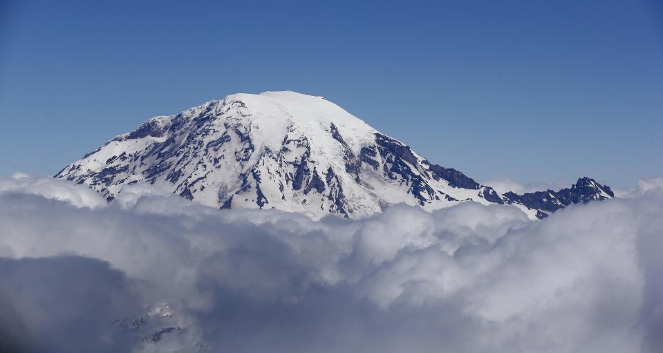 In this photo taken Wednesday, June 19, 2013, Mount Rainier, at risk to nearby populations from eruption and volcanic mudflows, is seen from a helicopter ferrying state officials south of the mountain and west of Yakima, Wash. | Elaine Thompson, Associated Press