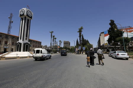 Civilians walk past the new clock tower in the old city of Homs June 3, 2015. REUTERS/Omar Sanadiki