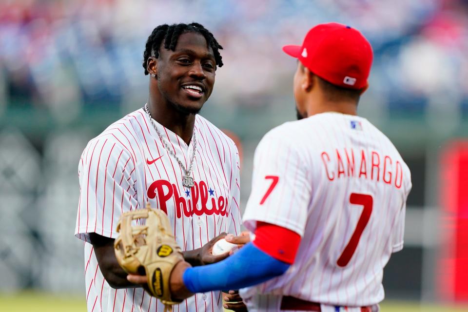 Philadelphia Eagles wide receiver A.J. Brown, left, meets with Philadelphia Phillies' Johan Camargo after throwing a first pitch before a baseball game between the Phillies and the Texas Rangers, Tuesday, May 3, 2022, in Philadelphia.