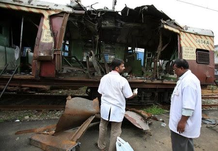 Forensic officers examine a damaged railway train compartment hit by bomb blast in Mumbai July 12, 2006. REUTERS/Punit Paranjpe/Files