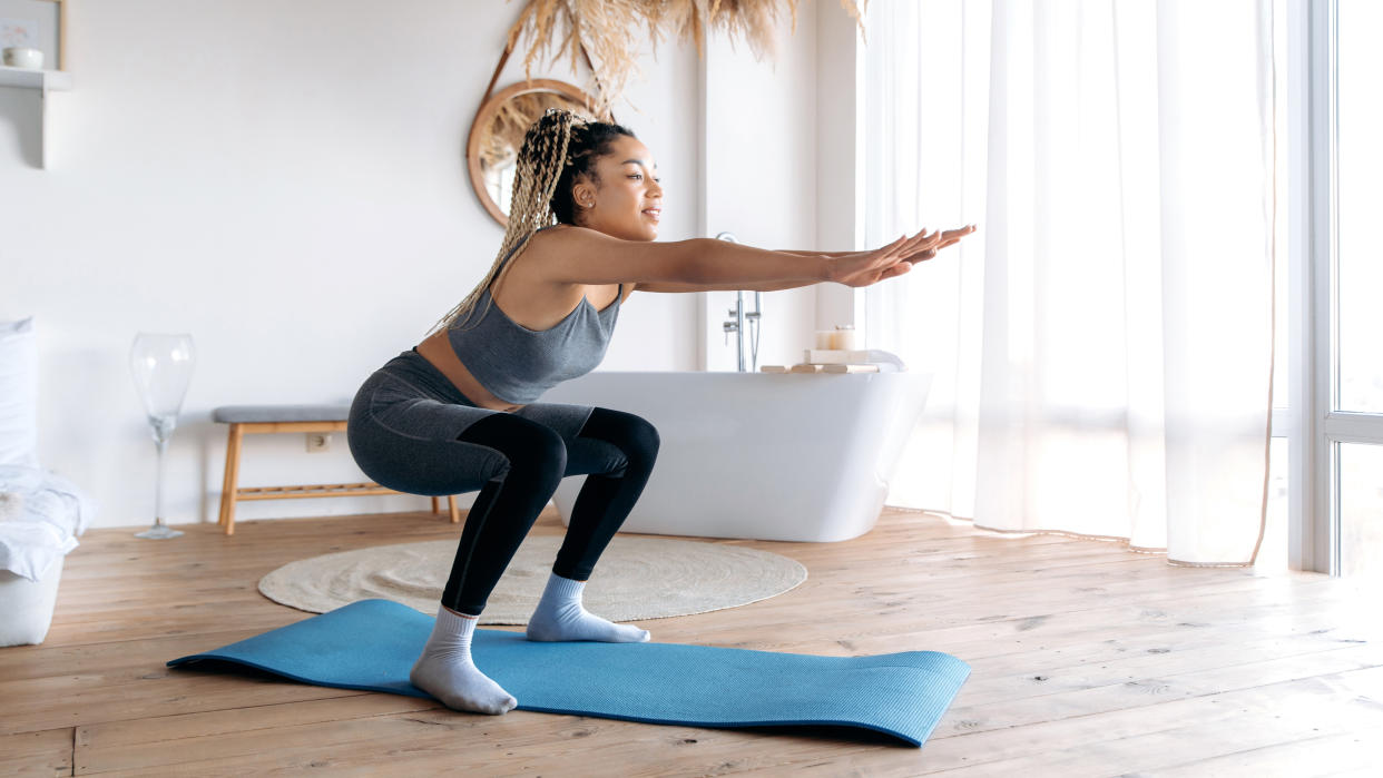  Woman holding a squat at home 