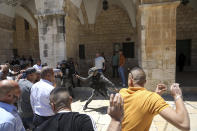 Israeli border police swing their batons at Muslim worshippers to prevent them from gathering for Friday prayers at the Dome of the Rock Mosque in the Al-Aqsa Mosque compound in the Old City of Jerusalem, Friday, May 14, 2021. (AP Photo/Mahmoud Illean)