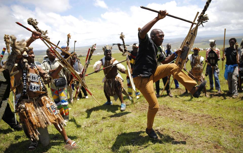 Zulu warriors dance to honor South Africa's late President Nelson Mandela on a hill above the graveyard within the Mandela family's property in the village of Qunu