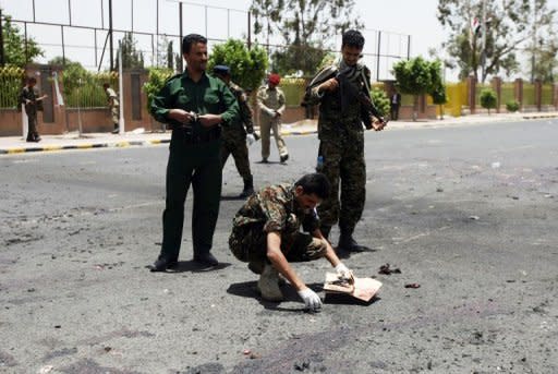 Forensic policemen collect evidence at the site of a suicide bomb attack in Sanaa on Monday. The suicide attack was the deadliest in the country's capital since newly-elected President Abdrabuh Mansur Hadi pledged to oust Al-Qaeda militants from Yemen's mostly lawless and restive southern and eastern provinces