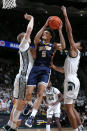 Toledo's Ryan Rollins, center, goes to the basket against Michigan State's Joey Hauser, left, and Max Christie during the first half of an NCAA college basketball game, Saturday, Dec. 4, 2021, in East Lansing, Mich. (AP Photo/Al Goldis)