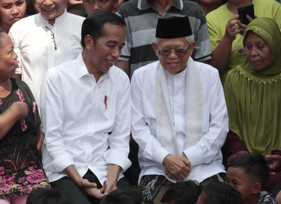 Incumbent Indonesian President Joko Widodo, center left, confers with his running mate Ma'ruf Amin prior to a speech declaring their victory in the country's presidential election, at a slum in Jakarta, Indonesia, Monday, Tuesday, May 21, 2019. Indonesian President Joko Widodo has been elected for a second term, official results showed, in a victory over a would-be strongman who aligned himself with Islamic hard-liners and vowed Tuesday to challenge the result in the country's highest court. (AP Photo/Dita Alangkara)