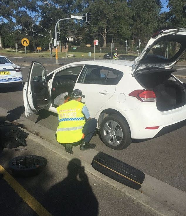 An officer from Hills Command police was praised online for assisting a couple found changing their tyre on Anzac Day, just day before another pair of officers were reprimanded for doing the same thing in Chatswood. Photo: Facebook
