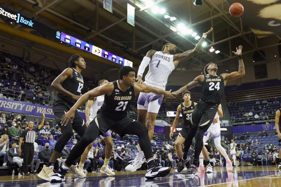 Washington forward Nate Roberts (1) and Colorado guard Elijah Parquet (24) leap for a rebound during the first half of an NCAA college basketball game, Thursday, Jan. 27, 2022, in Seattle. (AP Photo/Ted S. Warren)