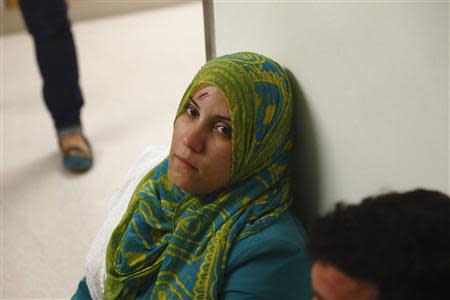 A rescued migrant sits in a corridor while waiting to undergo preliminary medical tests at Mater Dei Hospital in Tal-Qroqq, outside Valletta, October 12, 2013. REUTERS/Darrin Zammit Lupi