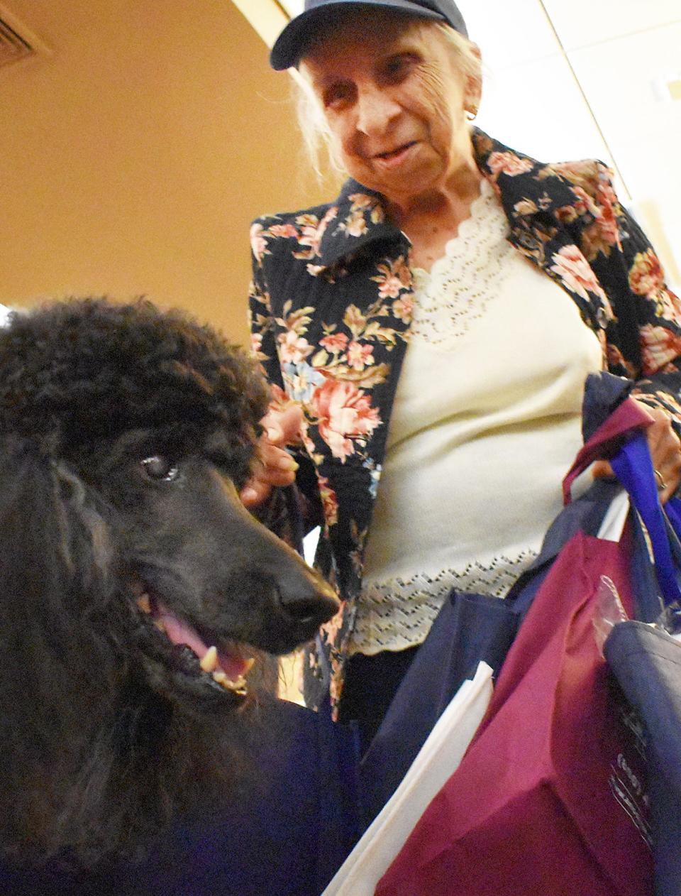 Agnes Aguiar, 93 of New Bedford, pets Shadow. Shadow was with Susan Robins of Dignity Hospice and Advanced Home Care at the annual Bristol County Celebration of Seniors conference Friday at White's of Westport.