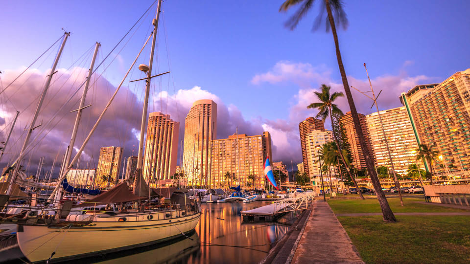 Beautiful panorama of sailing boats docked at the Ala Wai Harbor the largest yacht harbor of Hawaii and Honolulu skyline at twilight.