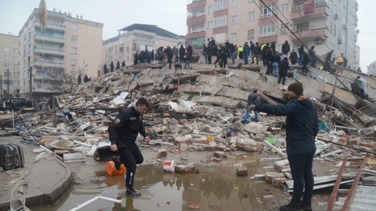 People search for survivors through the rubble in Diyarbakir, on February 6, 2023, after a 7.8-magnitude earthquake struck the country's south-east. - At least 284 people died in Turkey and more than 2,300 people were injured in one of Turkey's biggest quakes in at least a century, as search and rescue work continue in several major cities. (Photo by ILYAS AKENGIN / AFP)