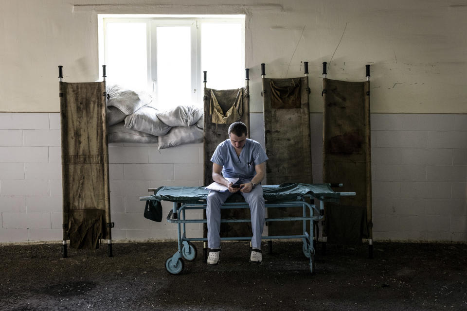 Médico descansando en una camilla afuera de un hospital donde son atendidos los militares heridos antes de trasladarlos hacia el oeste, en Kramatorsk, Ucrania, el miércoles 1° de junio de 2022. (Ivor Prickett/The New York Times)