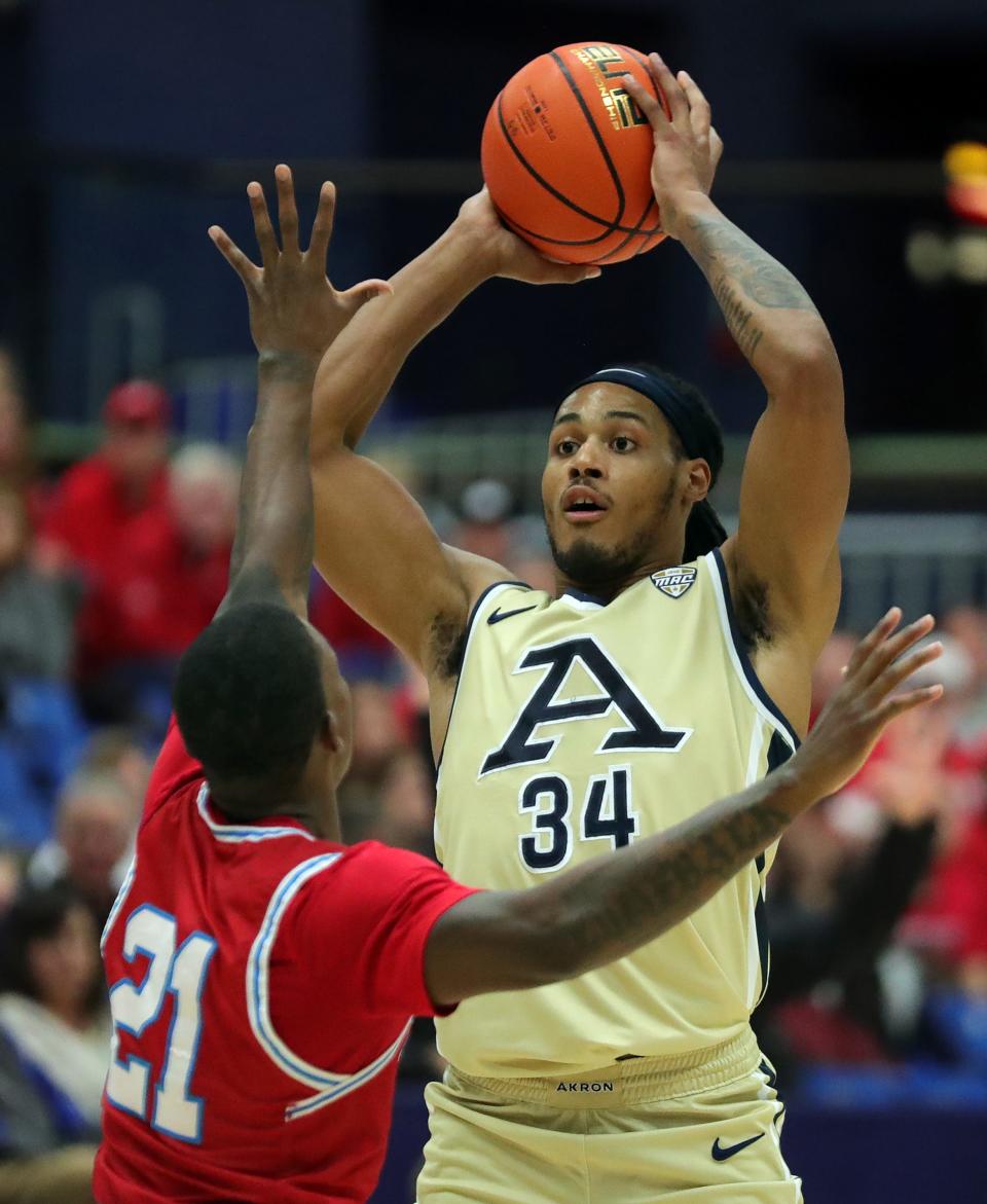 Akron Zips guard Nate Johnson looks to pass over Bradley guard Duke Deen on Dec. 5, 2023, in Akron.