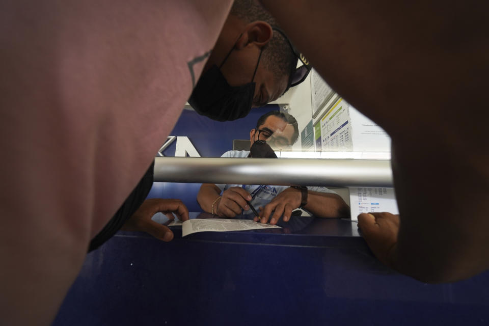 Migrants purchase bus tickets after receiving documents that allow them to legally travel through Mexico, in Huixtla, Chiapas state, Mexico, Friday, June 10, 2022. Thousands of migrants left Tapachula by foot at the start of the week, tired of waiting for normalize their status in a region with little work, with the ultimate goal of reaching the U.S. (AP Photo/Marco Ugarte)