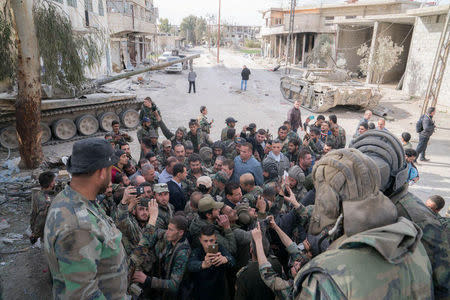 Syrian President Bashar al-Assad meets with Syrian army soldiers in eastern Ghouta, Syria, March 18, 2018. SANA/Handout via REUTERS