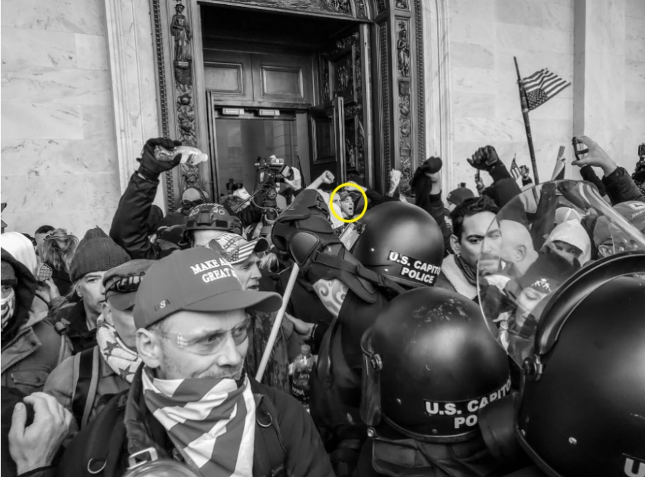 An image from a federal arrest warrant application shows Conlin Weyer, circled in yellow by federal authorities, among a wave of rioters pushing past police in the U.S. Capitol Building on Jan. 6, 2021, as members of Congress met to certify the 2020 presidential election.