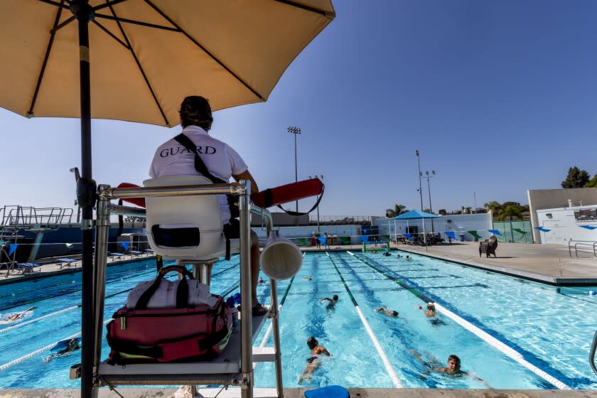 CARLSBAD, CA- JUNE 30, 2022: Senior lifeguard Ravelle Morales, 28, keeps an eye on young swimmers at Monroe Street Pool on June 30, 2022 in Carlsbad, California. Morales has been lifeguarding for 9 years. There is a lifeguard shortage in California. Right now, there is a new bill AB 1672 that would allow ocean lifeguards to work at public pools amidst this shortage.(Gina Ferazzi / Los Angeles Times)