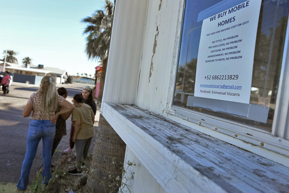 Residents of the Periwinkle Mobile Home Park socialize outside their homes, Thursday, April 11, 2023, in Phoenix. Residents of the park are facing an eviction deadline of May 28 due to a private university's plan to redevelop the land for student housing. (AP Photo/Matt York)