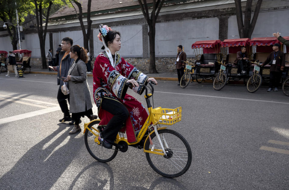 一名北京婦女穿著漢服踩單車，看似要將漢服融入日常生活。 (Kevin Frayer/Getty Images)