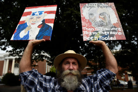 Daniel Gray, an artist from Crozet, Virginia, holds his paintings before "Charlottesville to D.C: The March to Confront White Supremacy," a ten-day trek to the nation's capital from Charlottesville, Virginia, U.S. August 28, 2017. REUTERS/Sait Serkan Gurbuz