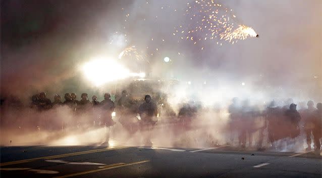 An explosive device deployed by police flies in the air as police and protesters clash. Photo: AP.