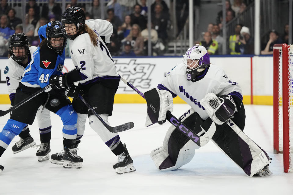 Minnesota goaltender Maddie Rooney (35) prepares to make a save as Toronto's Blayre Turnbull (40) is defended by Minnesota's Lee Stecklein (2) during the third period of Game 5 of a PWHL playoff hockey series Friday, May 17, 2024, in Toronto. (Frank Gunn/The Canadian Press via AP)