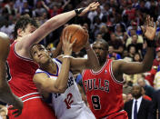 Philadelphia 76ers' Evan Turner (12) fights his way to the basket past Chicago Bulls' Omer Asik, of Turkey, and Luol Deng, (9) late in the fourth quarter of Game 3 in an NBA basketball first-round playoff series in Philadelphia, Friday, May 4, 2012. The 76ers won 79-74. (AP Photo/Mel Evans)