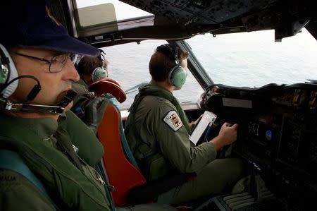 Co-Pilot, Flying Officer Marc Smith (R) and crewmen aboard a Royal Australian Air Force (RAAF) AP-3C Orion aircraft, search for the missing Malaysian Airlines Flight MH370 over the southern Indian Ocean March 24, 2014. REUTERS/Richard Wainwright/Pool