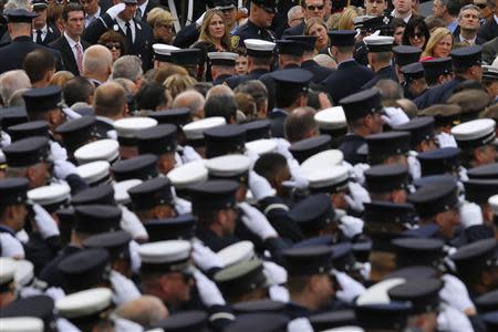 Family members (top) watch as firefighters salute while the body of Boston Fire Department Lieutenant Edward Walsh arrives for his funeral at Saint Patrick's Church in Watertown, Massachusetts April 2, 2014. REUTERS/Brian Snyder