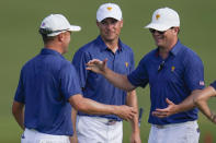 Justin Thomas, left, and Jordan Spieth, center celebrate with USA team captain Davis Love III, after winning their match on the 15th green during their fourball match at the Presidents Cup golf tournament at the Quail Hollow Club, Saturday, Sept. 24, 2022, in Charlotte, N.C. (AP Photo/Julio Cortez)