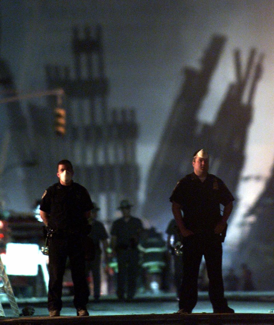 FILE - In this Sept. 12, 2001, file photo, policemen stand guard near the site of the World Trade Center in New York. (AP Photo/Beth A. Keiser)