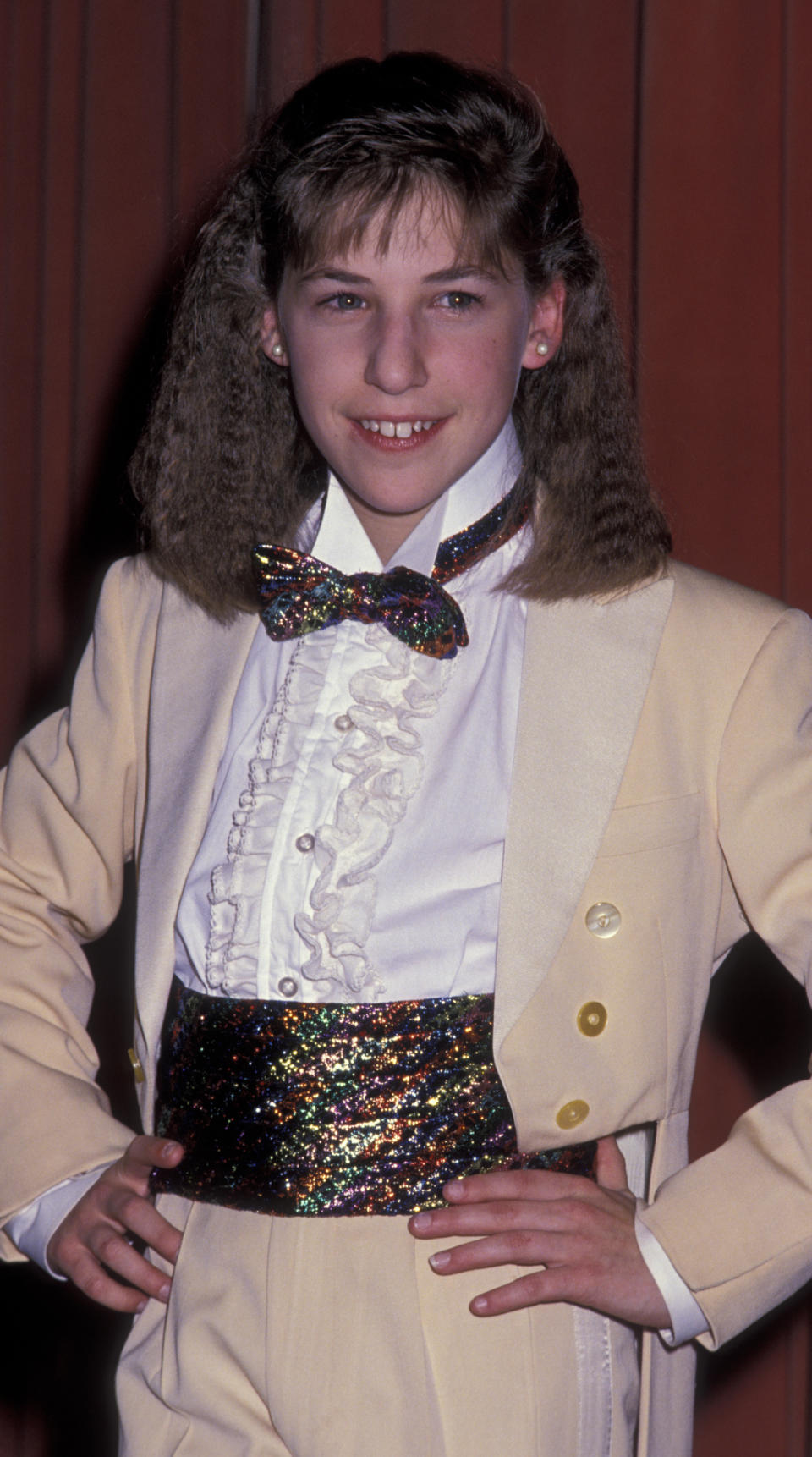 wearing a bow tie and suit with her hair crimped