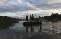 Residentes locales atraviesan el río Suchiate de México a Guatemala con cajas de huevos, cerca de Ciudad Hidalgo, en el estado de Chiapas, México, el viernes 17 de enero de 2020. (AP Foto/Marco Ugarte)