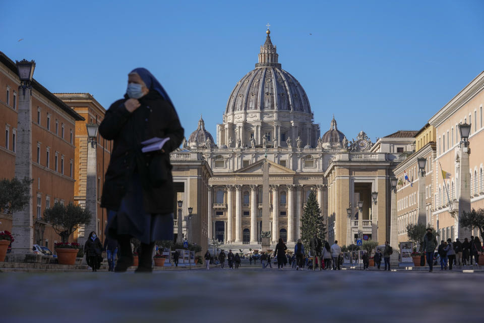 A nun walks past St. Peter's Square and Basilica, at the Vatican, Friday, Dec. 17, 2021. Pope Francis is celebrating his 85th birthday Friday, a milestone made even more remarkable given the coronavirus pandemic, his summertime intestinal surgery and the weight of history: His predecessor retired at this age and the last pope to have lived any longer was Leo XIII over a century ago. (AP Photo/Andrew Medichini)