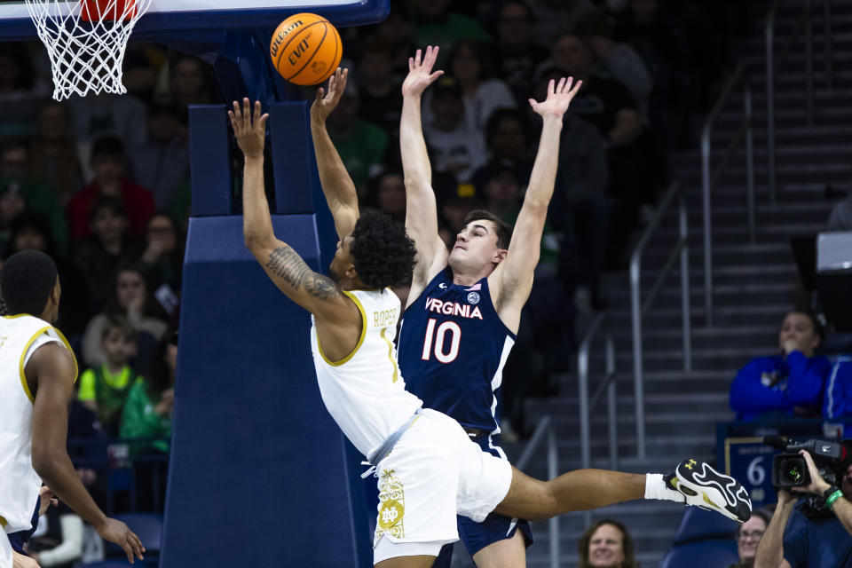 Notre Dame's Julian Roper II (1) drives to the basket as Virginia's Taine Murray (10) defends him during the first half of an NCAA college basketball game on Saturday, Dec. 30, 2023, in South Bend, Ind. (AP Photo/Michael Caterina)