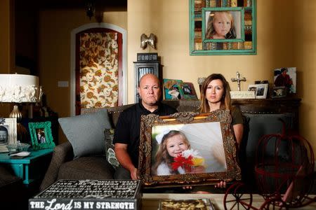 Kelly and Ryan Breaux sit holding a portrait of their deceased daughter Emma Breaux in their home in Breaux Bridge, Louisiana, on June 16, 2016. The husband and wife lost twins, Emma and Talon, to different superbugs that they contracted while in the neonatal unit at Lafayette General Hospital. U.S. Picture taken June 16, 2016. REUTERS/Edmund Fountain