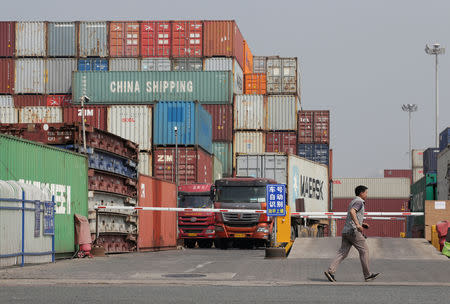 FILE PHOTO: A man walks next to containers in a logistics center near Tianjin Port, in northern China, May 16, 2019. REUTERS/Jason Lee/File Photo