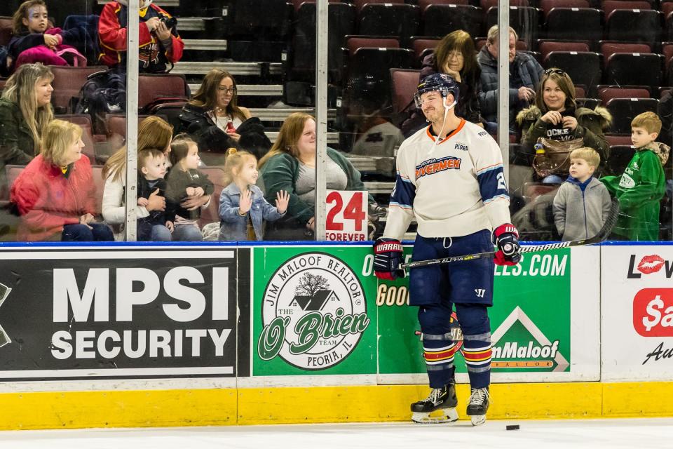 Peoria Rivermen defenseman Ben Oskroba stands by a sign posted in his honor by fans before the final game of his pro career on Sunday, Nov. 15, 2023 at Carver Arena.