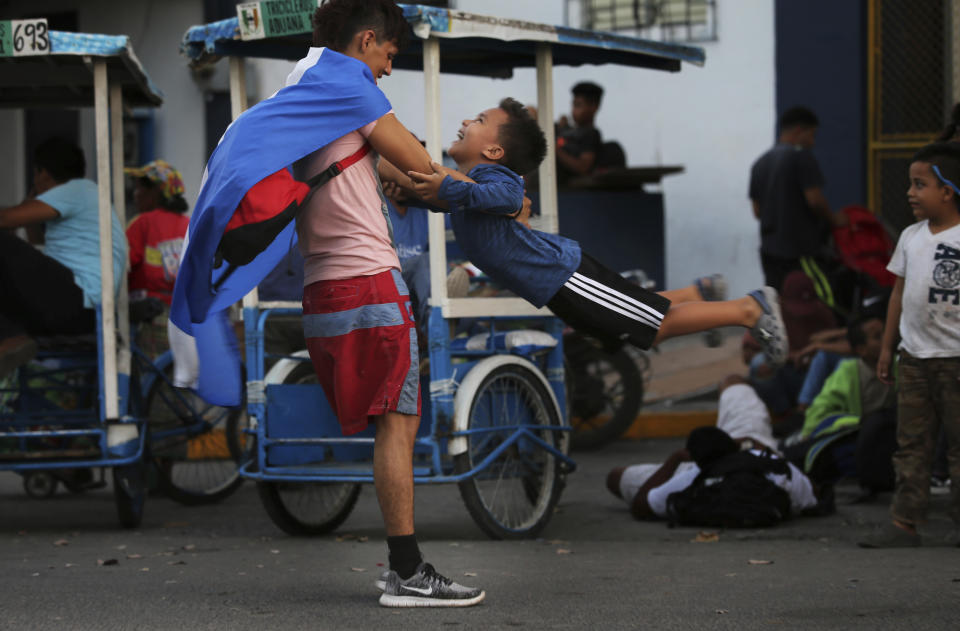 Migrantes hondureños juegan mientras esperan para cruzar la frontera a México, en Tecun Uman, Guatemala, el 17 de enero de 2020. (AP Foto/Marco Ugarte)