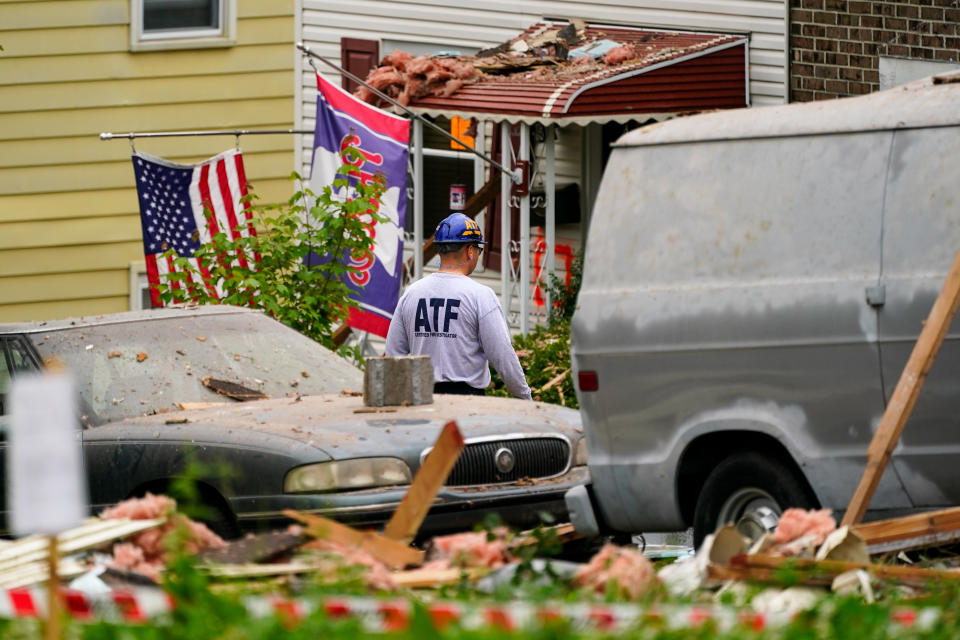 An investigator moves through the scene of a deadly explosion in a residential neighborhood in Pottstown, Pa., Friday, May 27, 2022. A house exploded northwest of Philadelphia, killing several people and leaving others injured, authorities said Friday. (AP Photo/Matt Rourke)