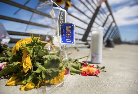 Flowers and a candle form a makeshift memorial for shooting victim Kathryn Steinle on Pier 14 in San Francisco, California July 6, 2015. Steinle, 32, was fatally shot as she walked with her father along the popular Embarcadero pier on July 1, 2015 in what San Francisco police described as an apparent random attack. The random fatal shooting, allegedly by an immigrant, proves the United States must tighten its borders, according to a statement on Friday by U.S. presidential candidate Donald Trump, who is facing heavy criticism for his comments about Mexicans. REUTERS/Noah Berger