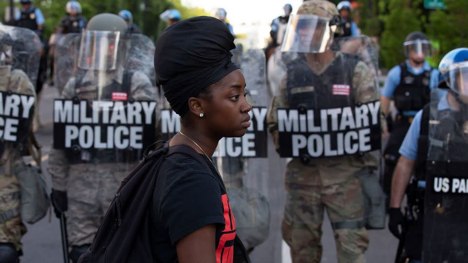 A demonstrator walks in front of a row of military police members wearing riot gear as they push back demonstrators outside of the White House, June 1, 2020 in Washington D.C., during a protest over the death of George Floyd. - Jose Lusi Magana/AFP/Getty Images