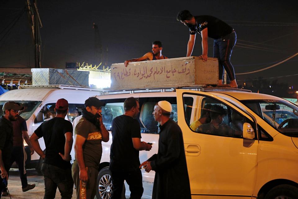 Mourners load the coffin of Saleh Ahmed, 27, a protester killed in an anti-government demonstration, during his funeral in Najaf, Iraq, Monday, Oct. 28, 2019. (AP Photo/Anmar Khalil)