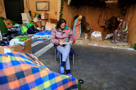 Angela Grossi sits next to her tent in the portico of the Basilica of the Santi Apostoli, where she lives after being evicted from an unused building along with other families in August 2017, in Rome, Italy January 29, 2018. Picture taken January 29, 2018. REUTERS/Tony Gentile