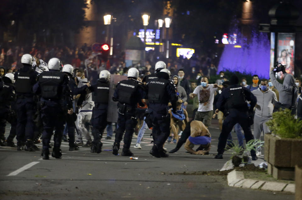 Serbian police officers clash with protesters near the parliament building in Belgrade, Serbia, Tuesday, July 7, 2020. Thousands of people protested the Serbian president's announcement that a lockdown will be reintroduced after the Balkan country reported its highest single-day death toll from the coronavirus Tuesday. (AP Photo/Darko Vojinovic)